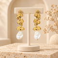 Boucles d’oreilles feuilles et perles sur présentoir beige