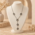 Collier argenté sur petit présentoir beige